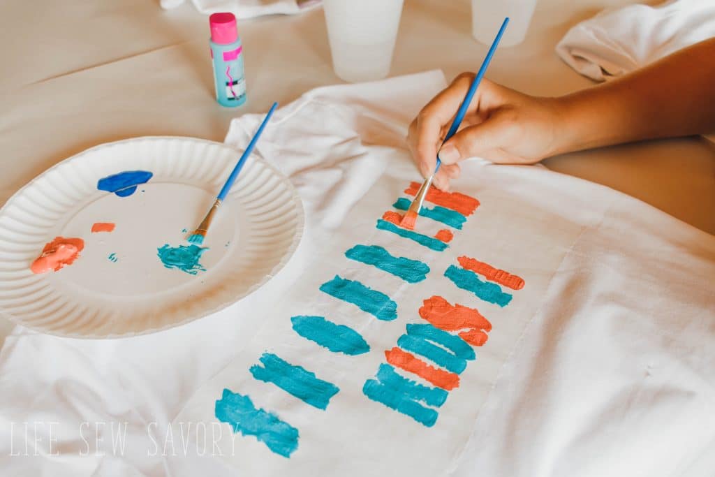 paint shirt with fabric paints inside stencil lines