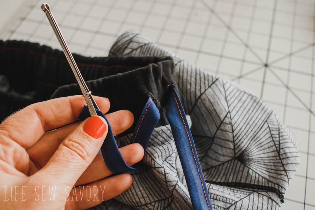 thread the elastic in one button hole and out the other