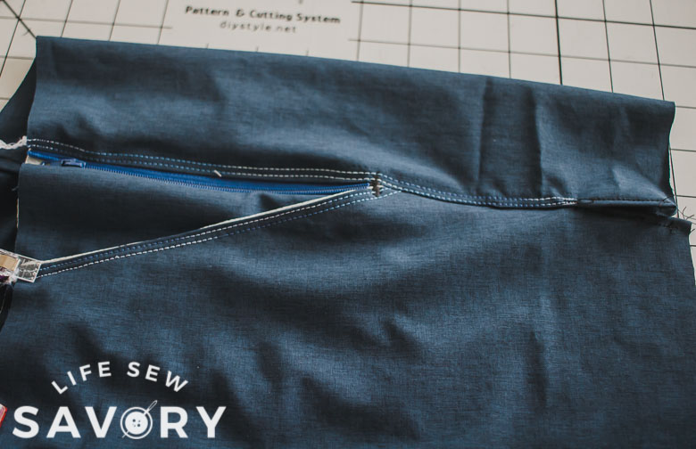 top stitch side seams to back, zig zag bottom of pocket to secure