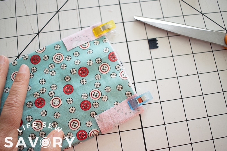 trim end fabric and fold over to back 1/2"