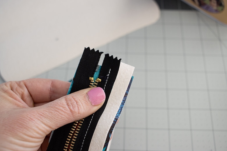 trim 1/4" off the end of the zipper, but leave room after the zipper