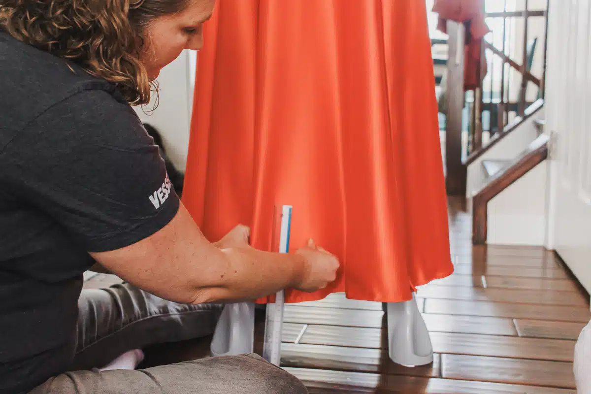 Professional seamstress hemming prom dress for proper length
